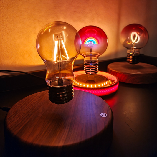 Three levitating light bulbs in three different styles - bulb, rainbow and heart on a wooden surface with warm lighting
