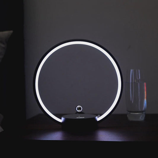 Round LED lamp with a white ring on a dark surface