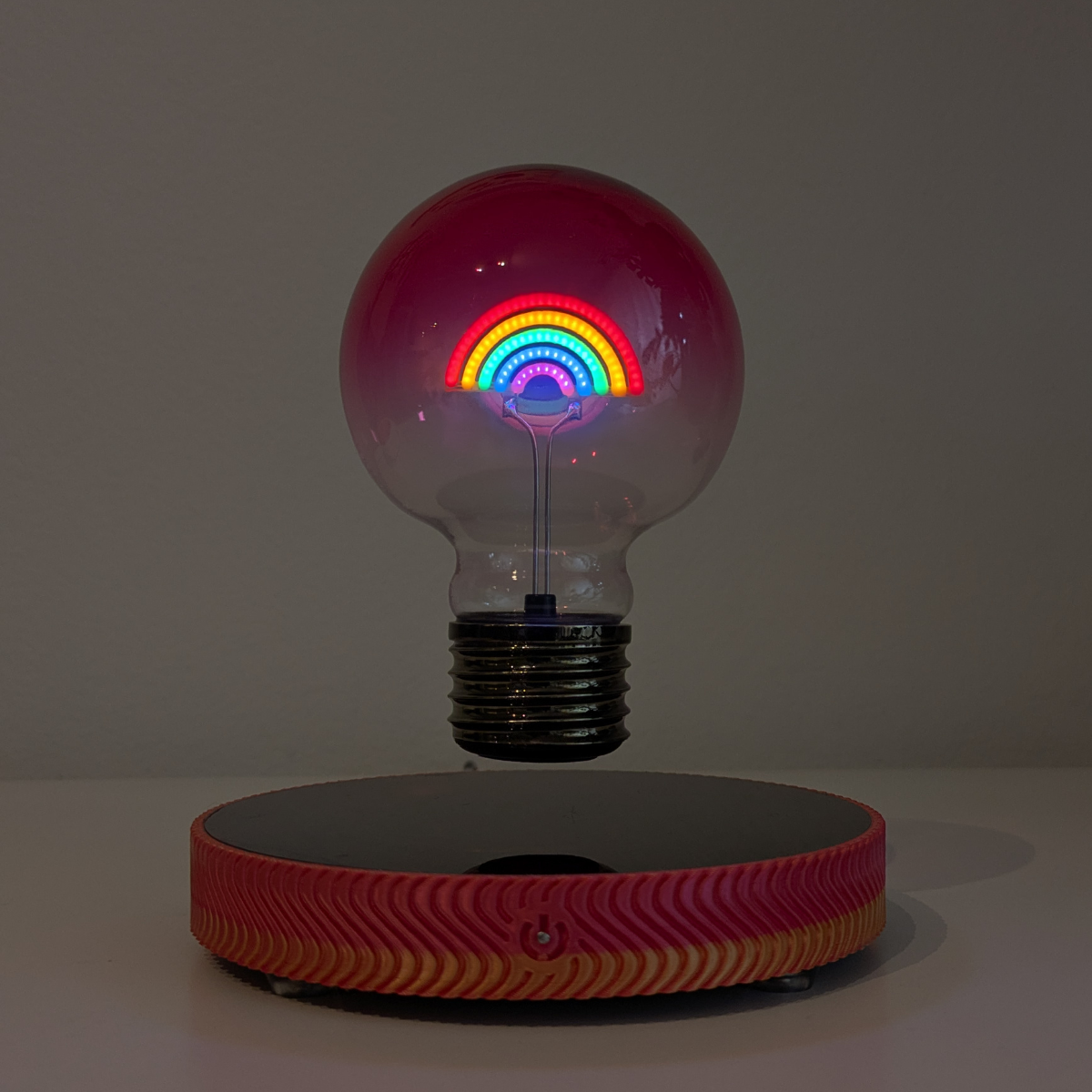 Levitating Rainbow Light Bulb Lamp Floating Above Glowing LED Base