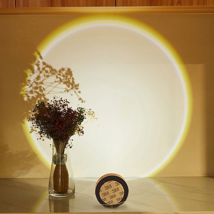 Vase with flowers on a table with a circular light projection on the wall.