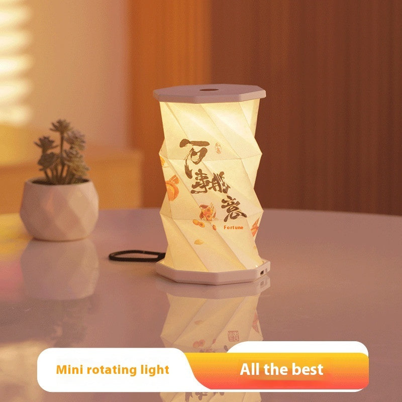 Decorative lantern with text on a reflective surface with a plant in the background