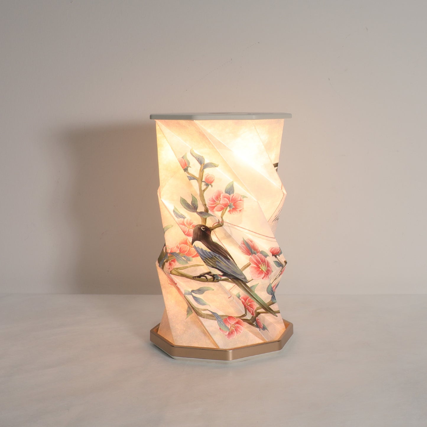 Decorative table lamp with floral and bird design on a plain background