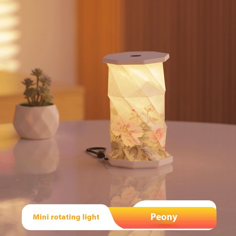 Decorative mini rotating light with floral design on a table, labeled 'Peony'.