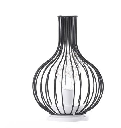 Black wire basket with a white candle inside on a white background