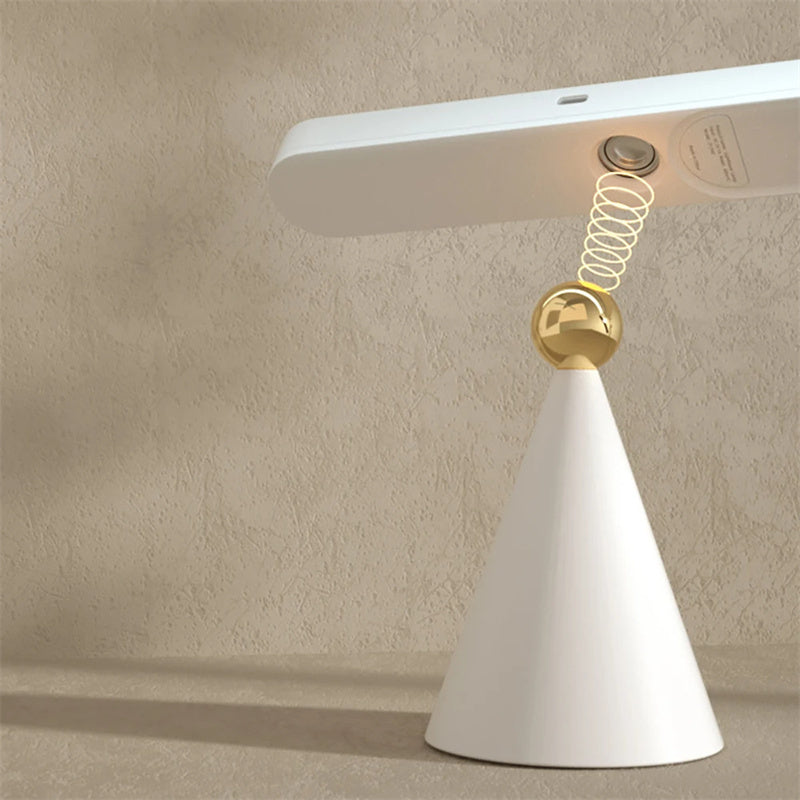 Modern table lamp with white base and gold accent on a beige background