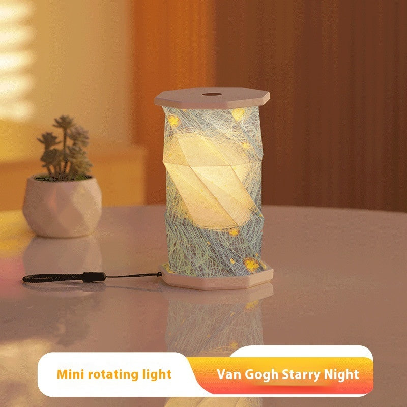 Mini rotating light inspired by Van Gogh's 'Starry Night' on a table with a plant in the background.