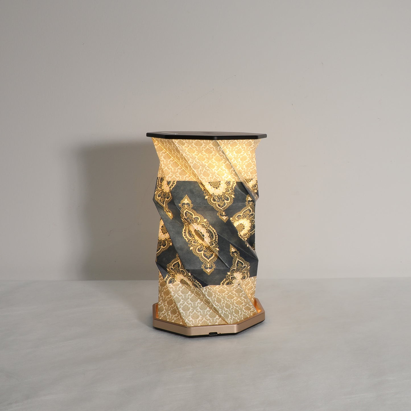 Decorative vase with gold and black pattern on a gray background