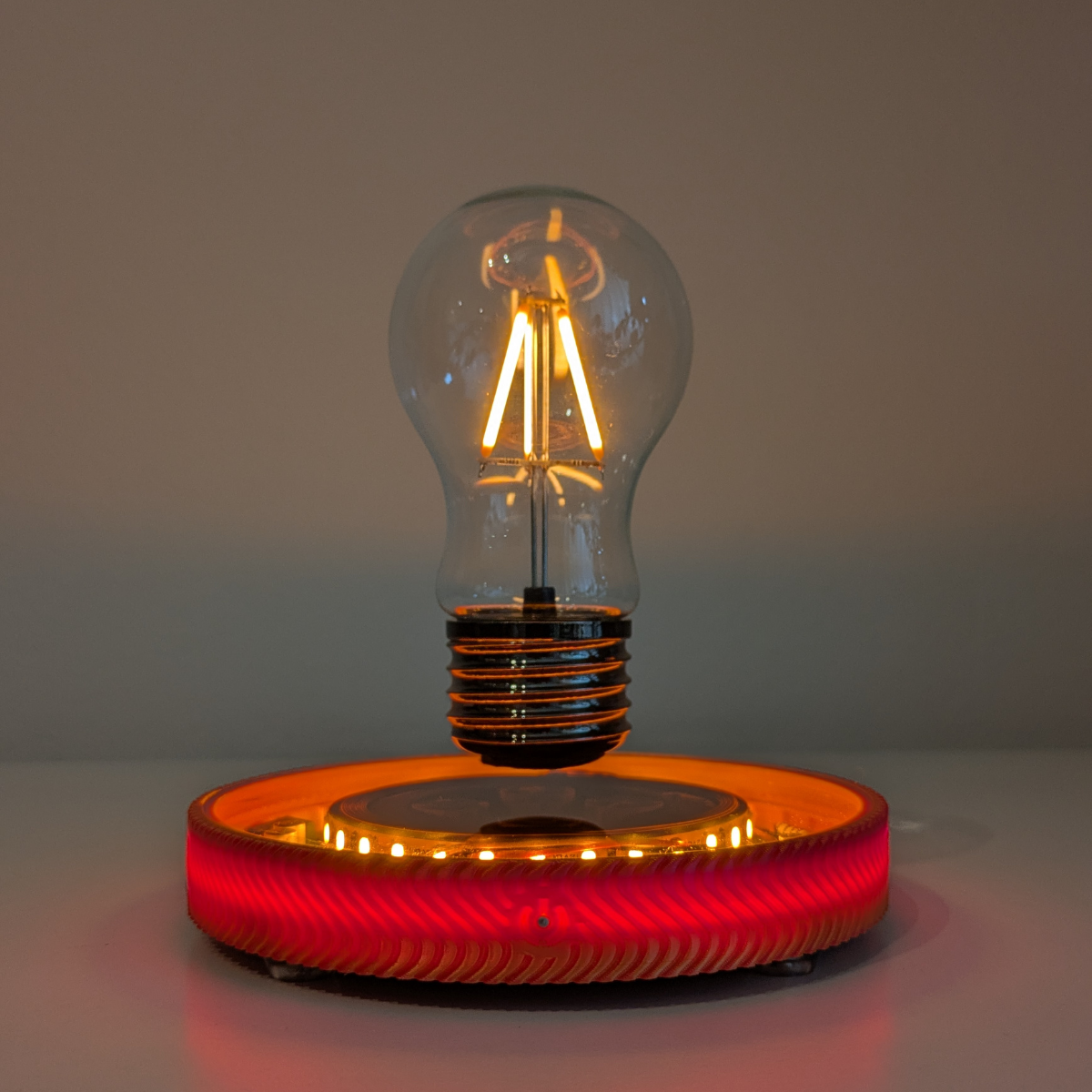 Levitating Vintage Filament Light Bulb Floating Above Glowing LED Base