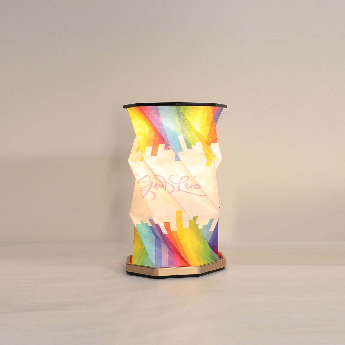 Colorful lamp with rainbow design on a plain background