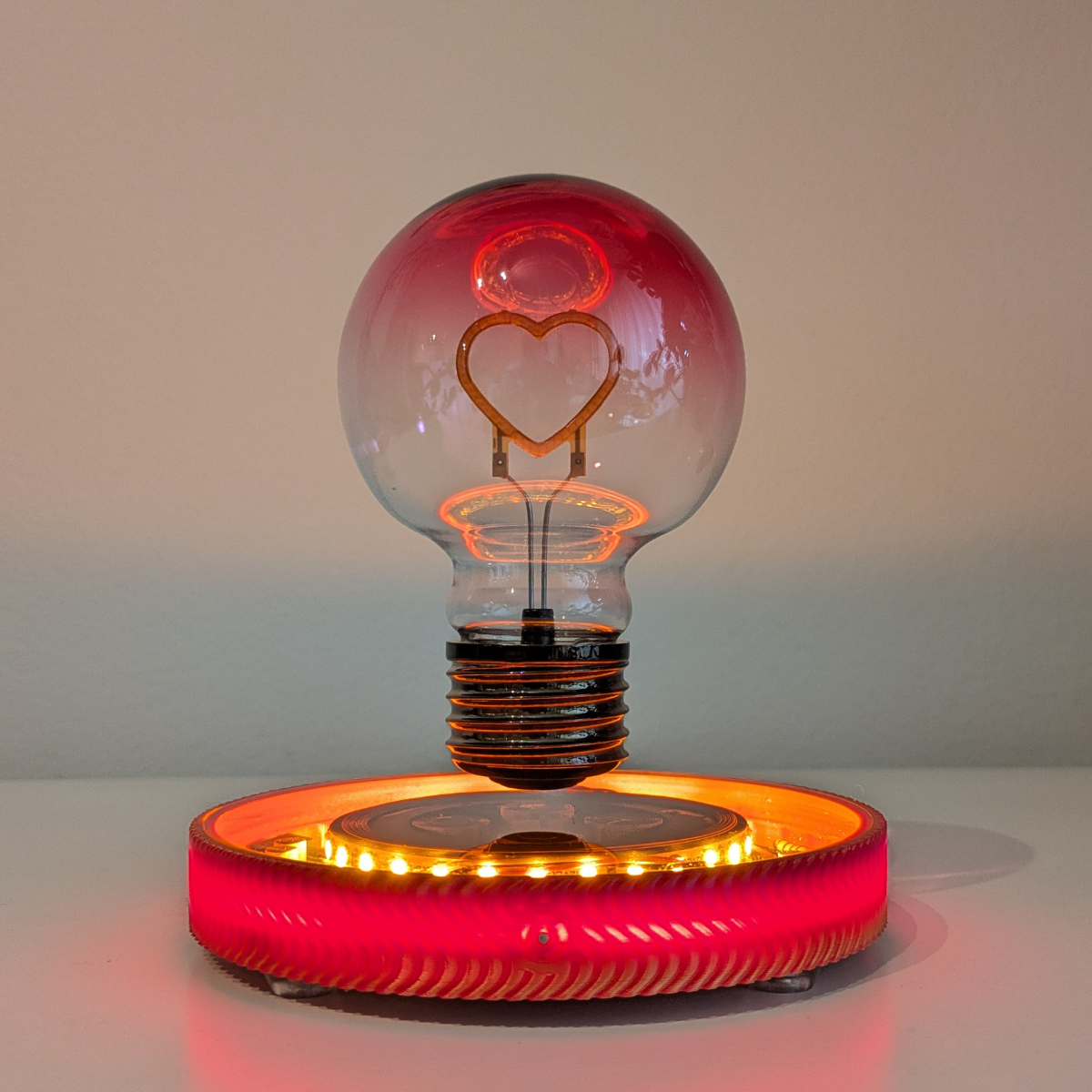 Levitating Heart Shaped Filament Light Bulb Floating Above Glowing LED Base