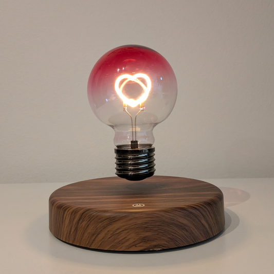 Levitating Heart Shaped Filament Light Bulb Floating Above Wooden Base