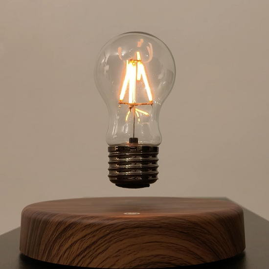 levitating vintage filament light bulb floating over wooden style base