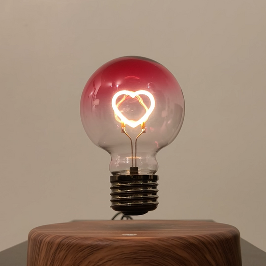 levitating light bulb with pink heart shaped ilament.