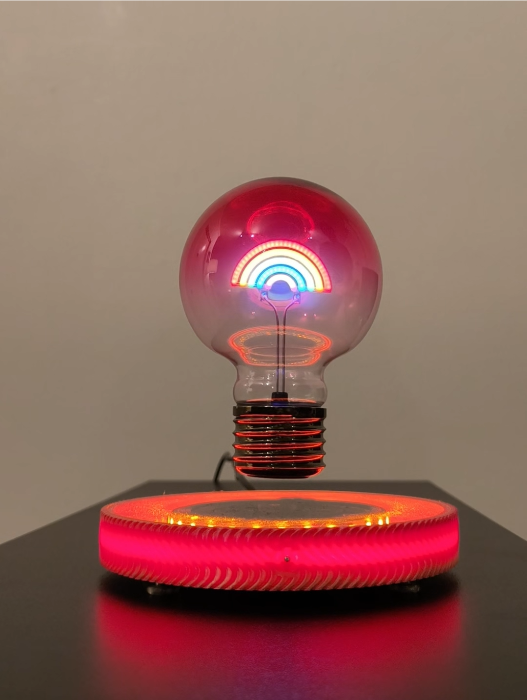 levitating rainbow LED light lamp, floating over glowing red and yellow LED base